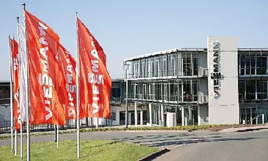 Sede Viessmann con bandiere rosse all'ingresso e edificio in vetro moderno
