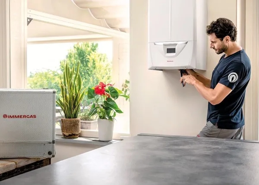 Tecnico Immergas installa caldaia a condensazione in ambiente domestico luminoso" title="Installazione caldaia Immergas da parte di tecnico specializzato